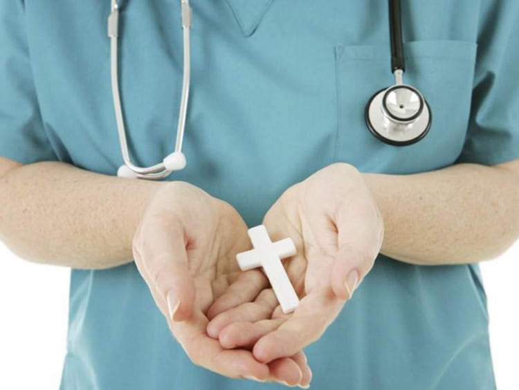 nurse holding a cross in hands