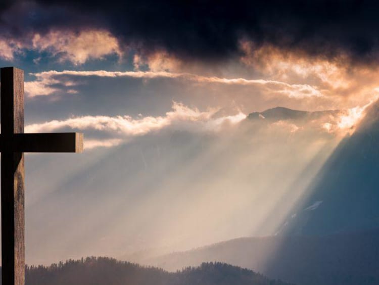 A cross facing golden sun-rays