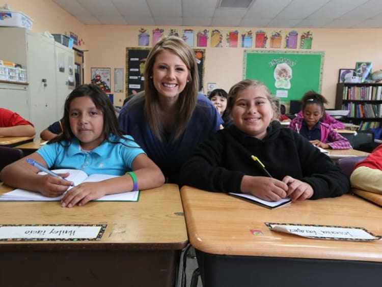 Woman teacher behind two students