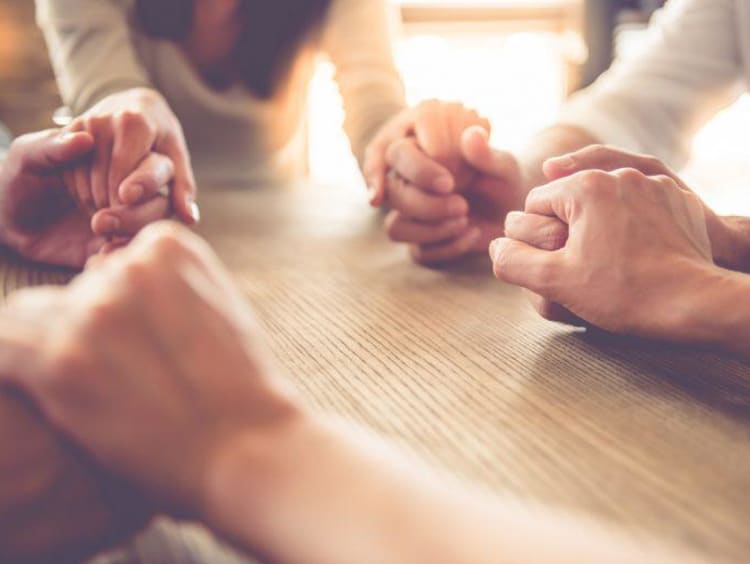 people holding hands in a circle