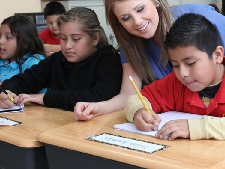 teacher helping her students in class