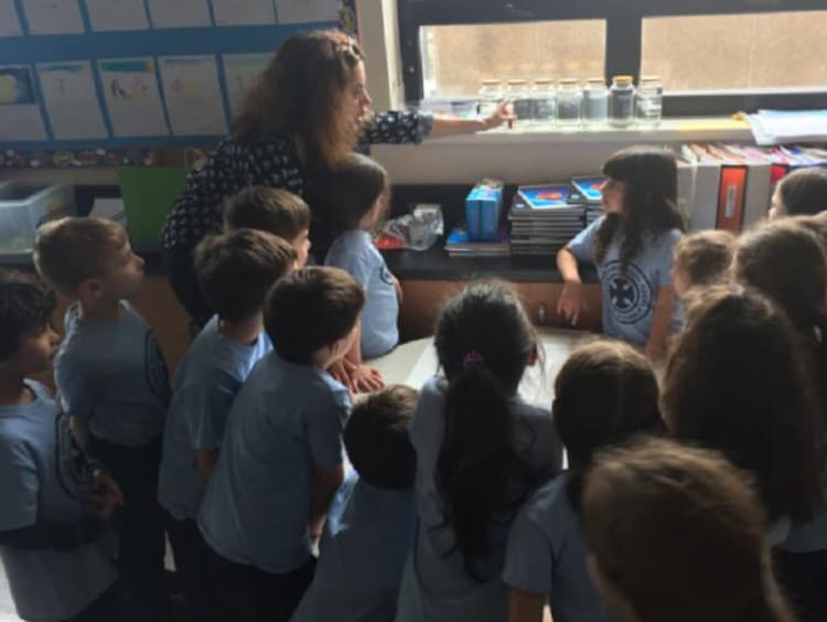 group of students surrounding a table in a classroom