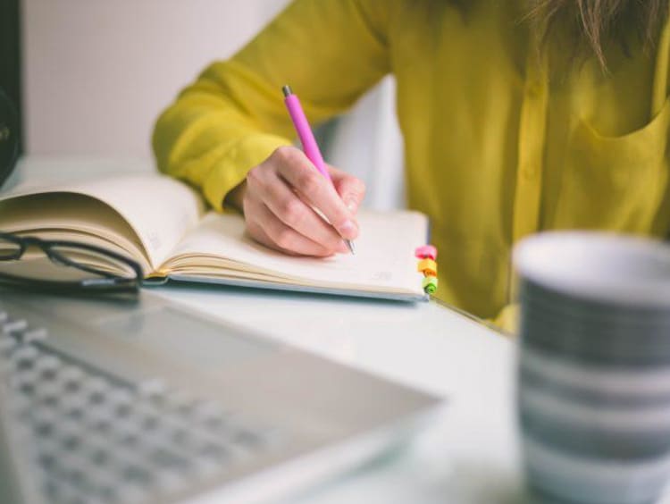 Handwriting, hand writes with a pen in a notebook