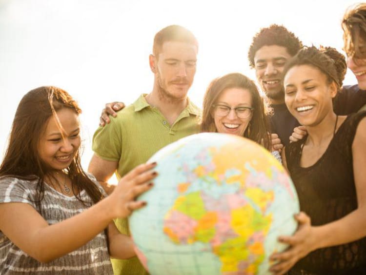 International students gathered around a globe