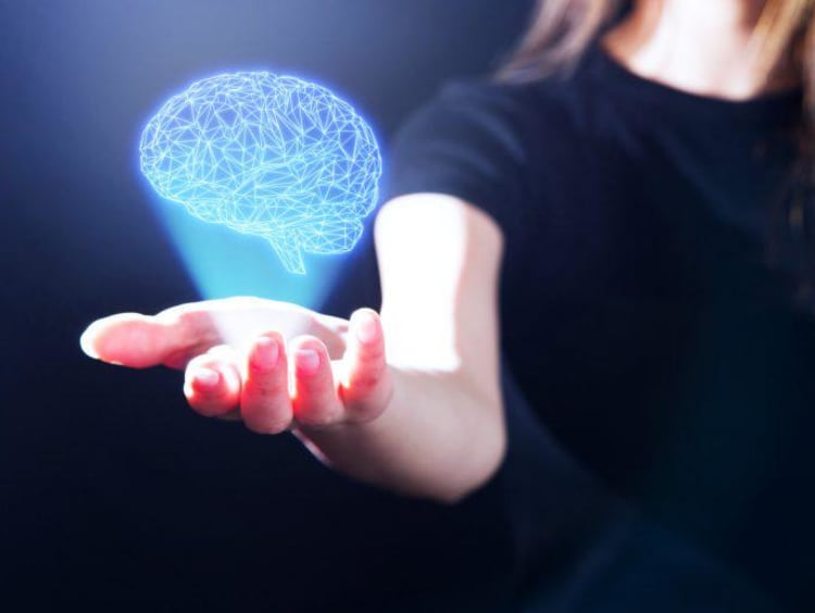 Woman holds her hand out with a virtual brain above it 