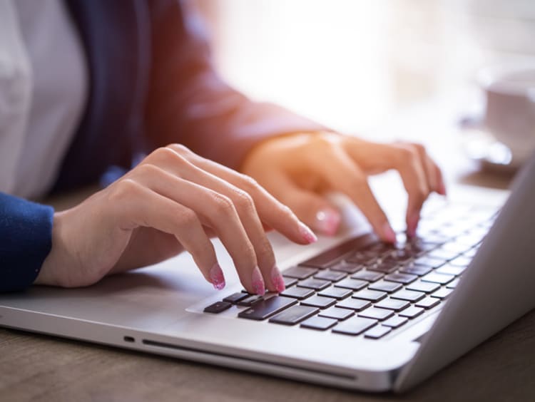 hands typing on laptop