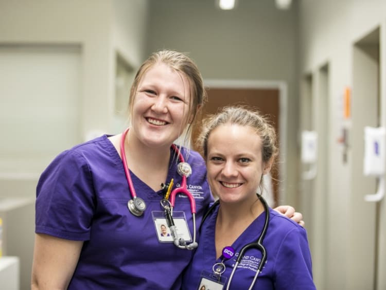 two GCU nurses standing in a hallway