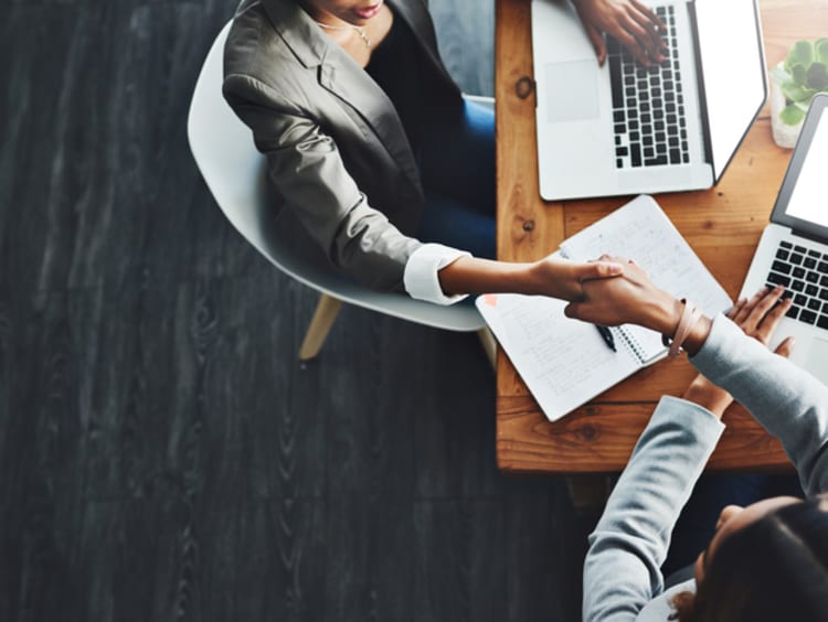 business people shaking hands over a desk