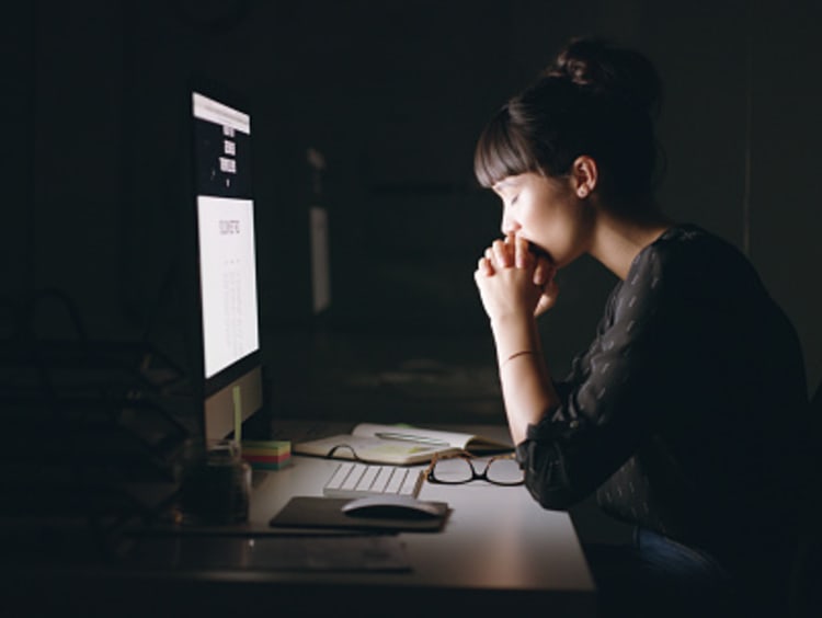 Woman praying and working for the Lord with her computer