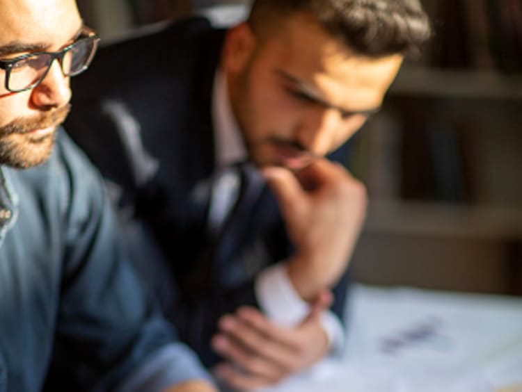 Two male market research analysts reviewing reports