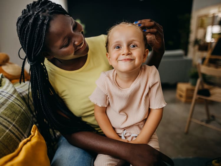 Foster mom sitting and smiling with foster daughter