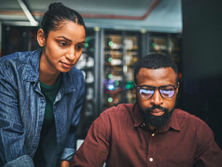 Two systems engineers work with computers