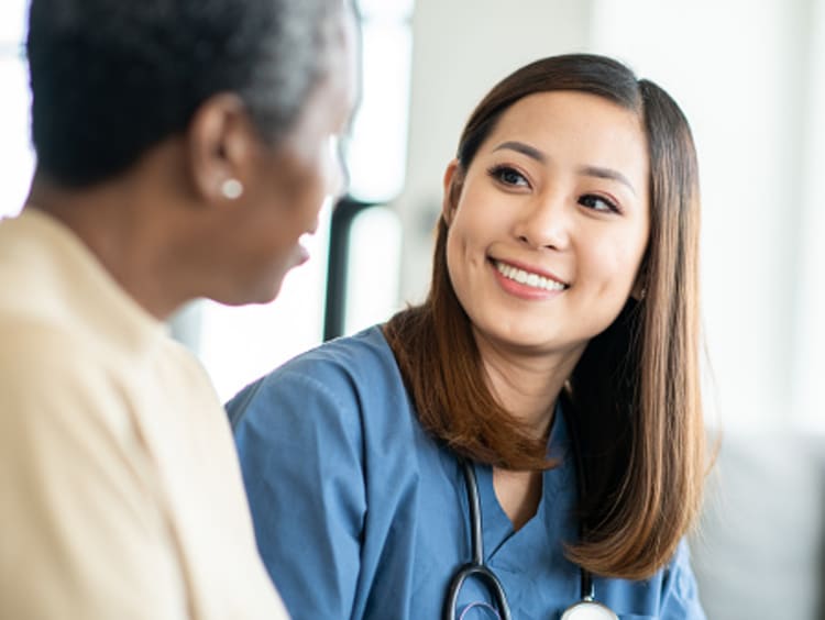 A nurse practitioner talks to an adult patient about their healthcare options.