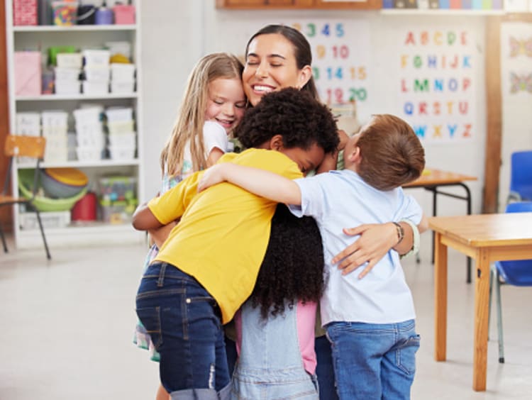 Diverse learners hugging their teacher