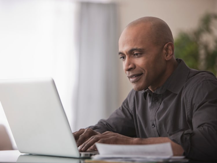 Professor replying to emails on laptop