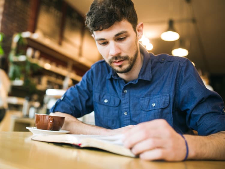 Man reading his Bible in a coffee shop