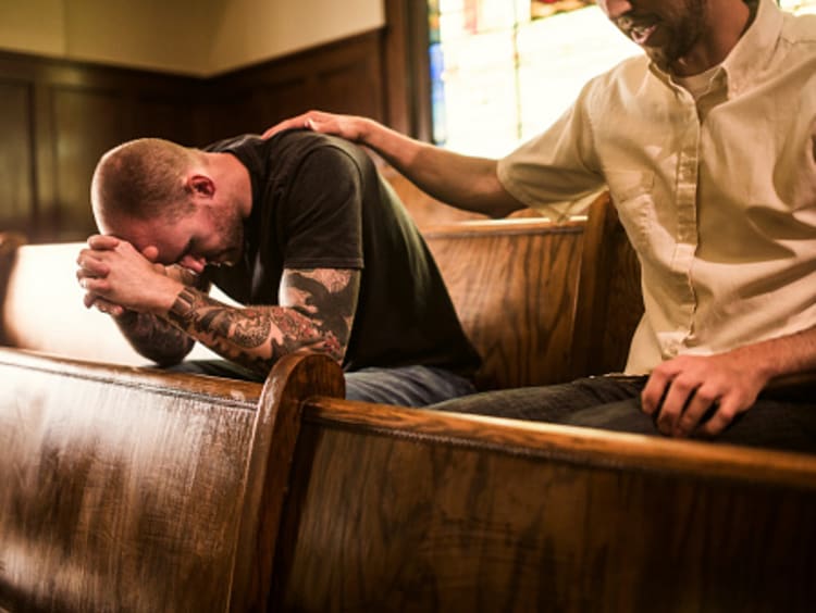 Men praying together as part of Christian practices