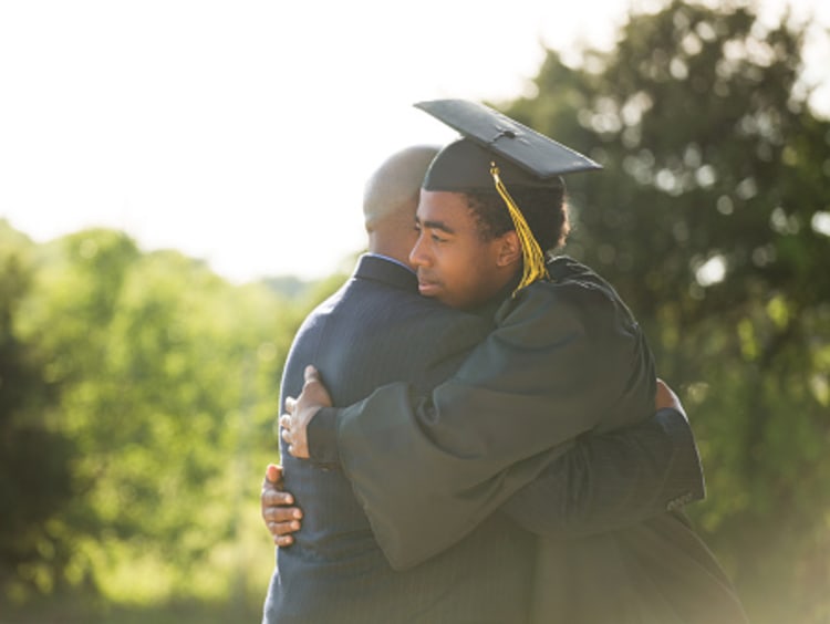 son hugging father after graduating doctoral program