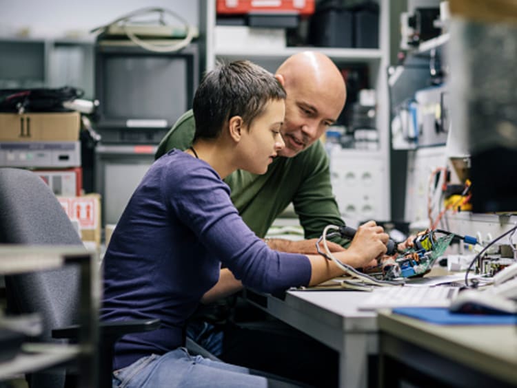 Student working with teacher on engineering degree project