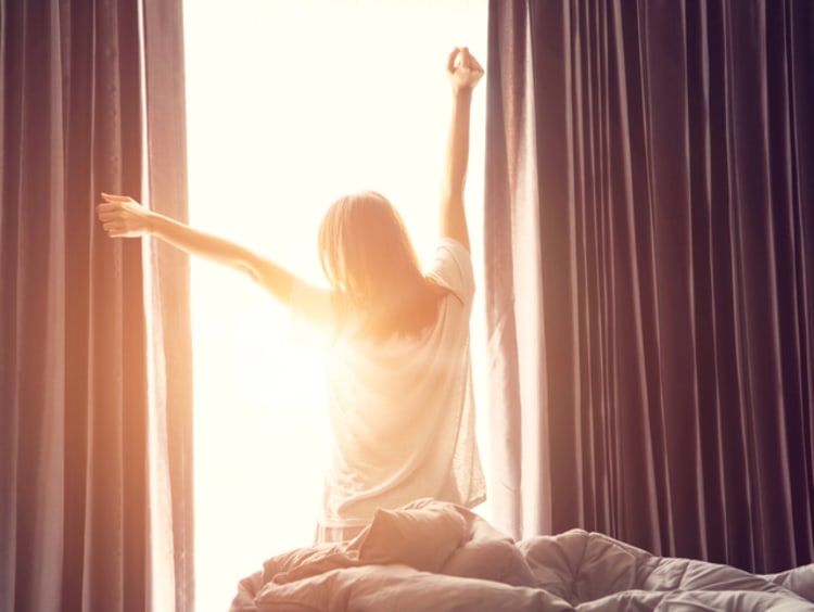 girl getting out of bed and stretching