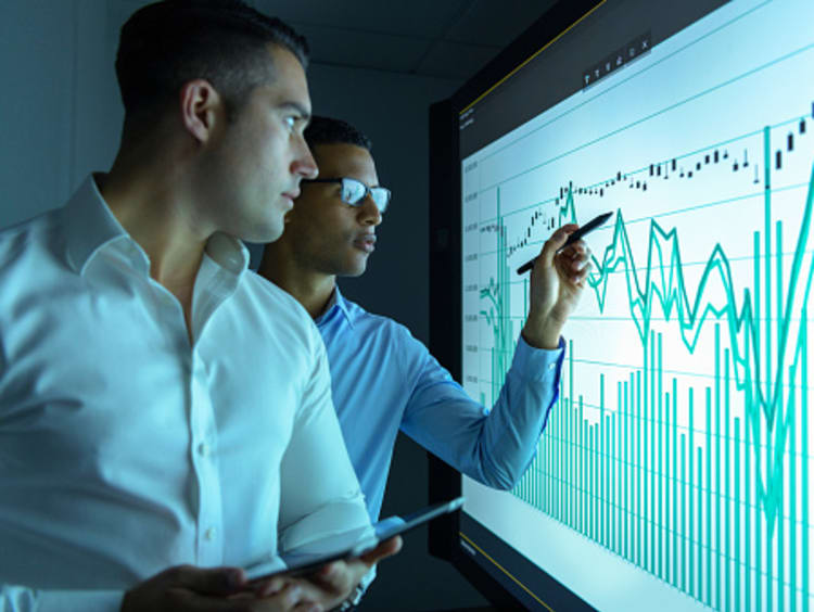 Computer science degree students analyzing data in computer lab