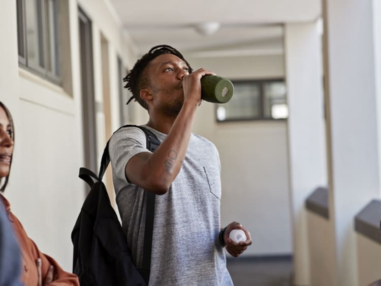 African-American male student drinking water