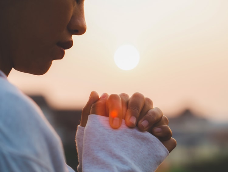 person holding their hands together praying