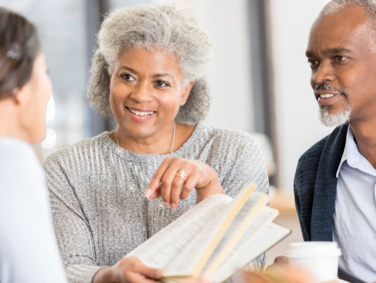 a group of three people reading the bible together