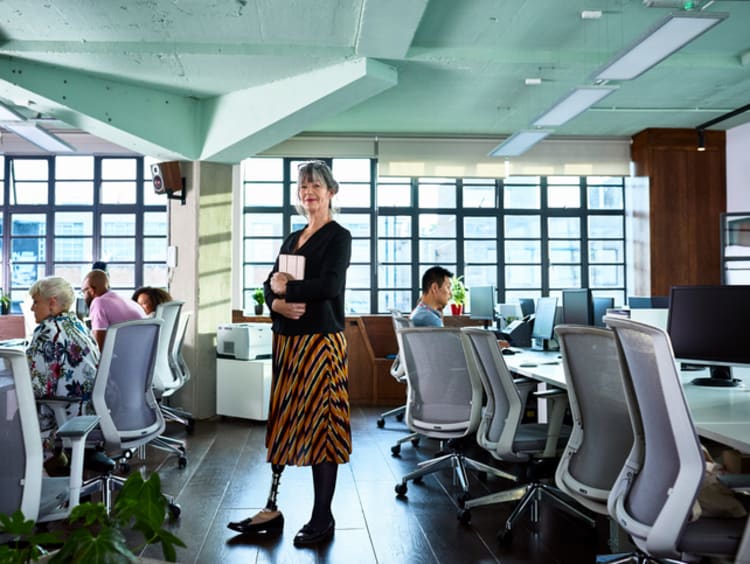 Woman standing in a room with with employees