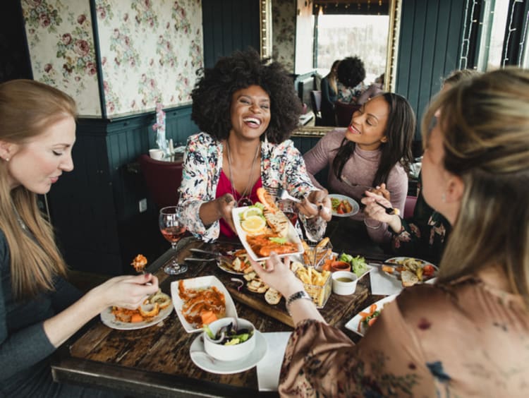 girls laughing and eating brunch