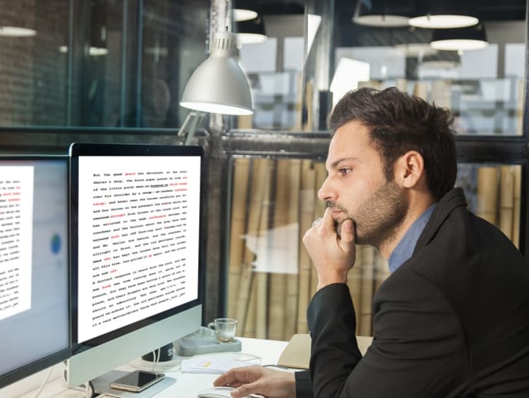 Editor reviewing document at computer