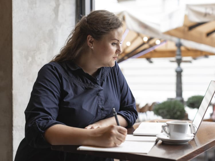 Female grant writer drafting proposal from home office