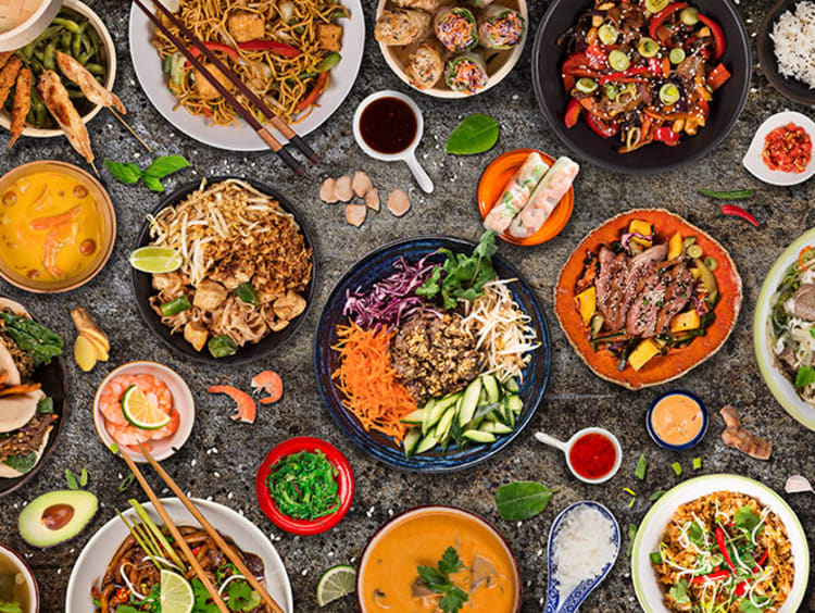 Table of plates featuring a variety of cuisine from other cultures