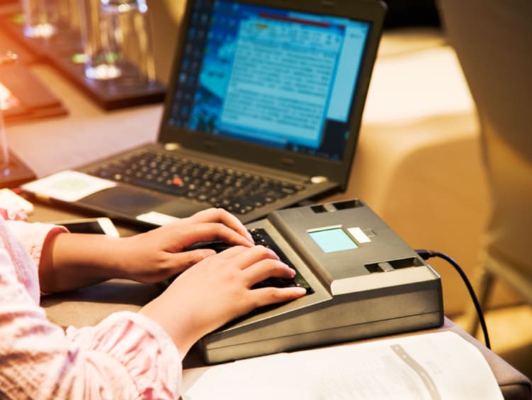 A stenographer working at a computer