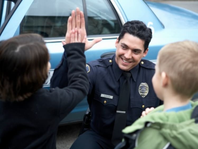 Public safety officer giving kids high-fives