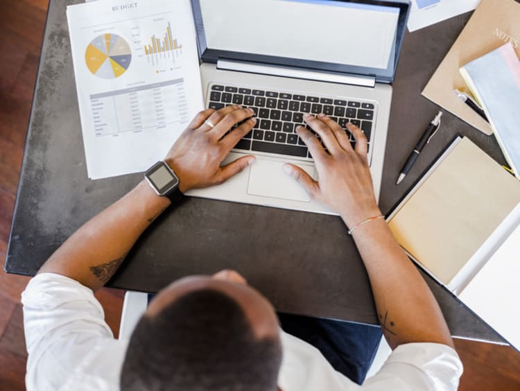 Research analyst typing on laptop