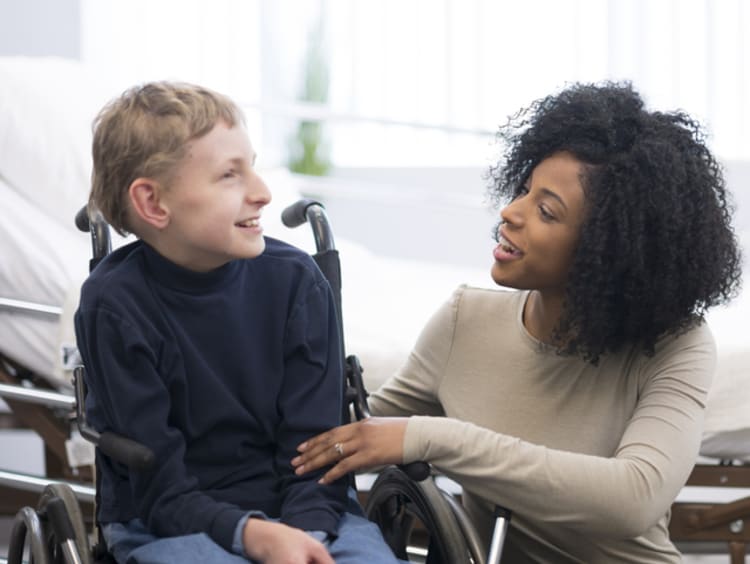 Female social worker talking with a child in a wheelchair