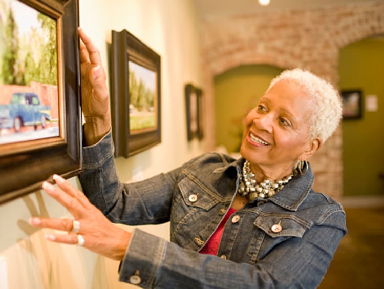 Museum curator inspecting painting