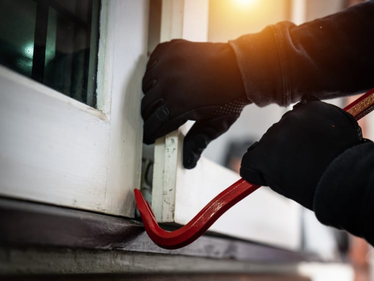 burglar breaking open a door with a crowbar