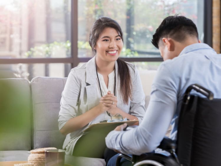 A vocational rehabilitation counselor talking with a man in a wheelchair to help him discover new career goals