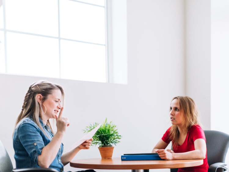 Social worker reading paperwork to young woman