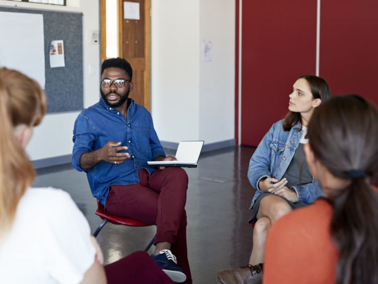 mental health professional with a psychology degree advising students in group session
