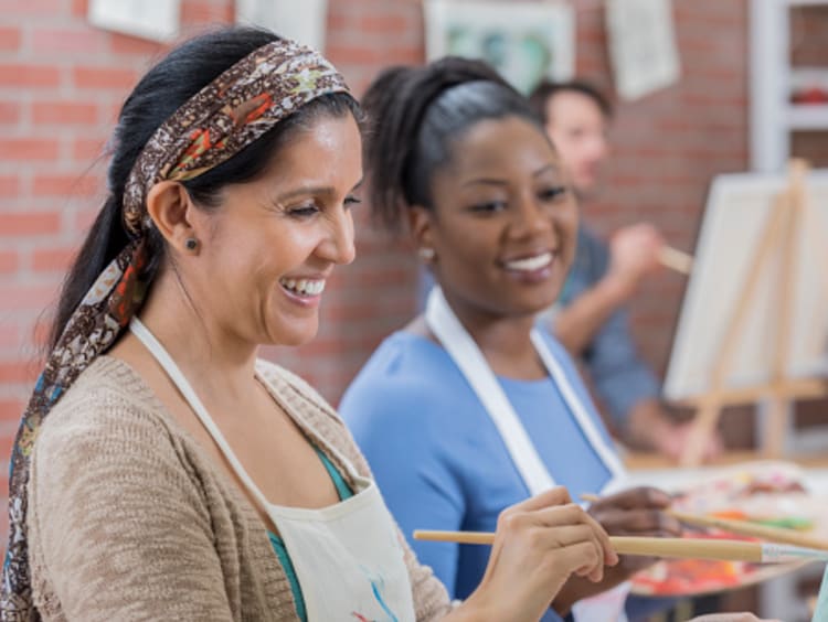 Art therapist and students painting in studio