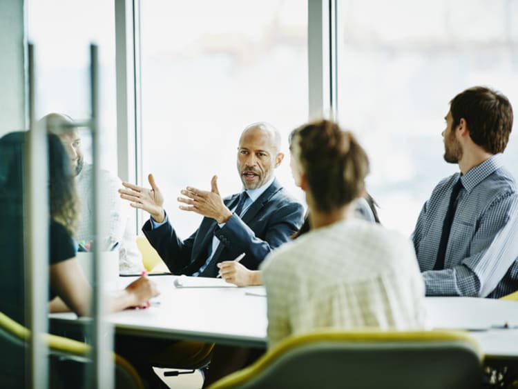 Male business leader with team in conference room