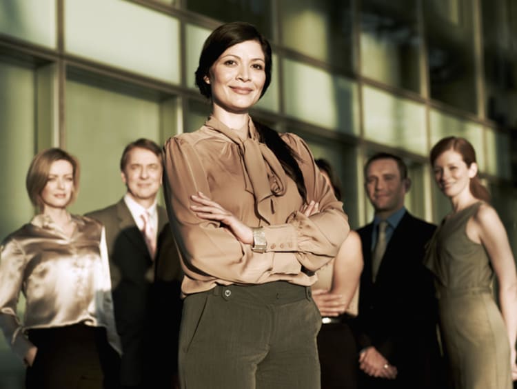 Woman stands confidently in front of her team