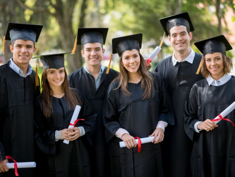 BSBA graduates smiling with their diplomas