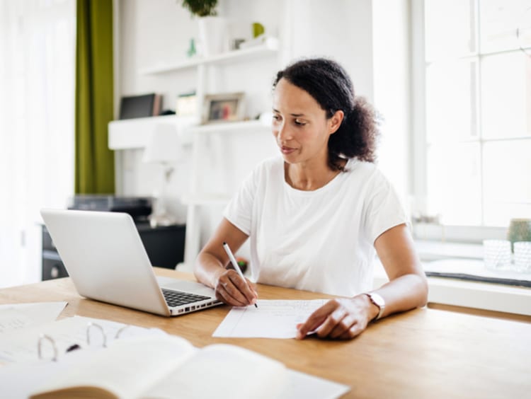 Female doctoral student working towards her online PhD on a laptop