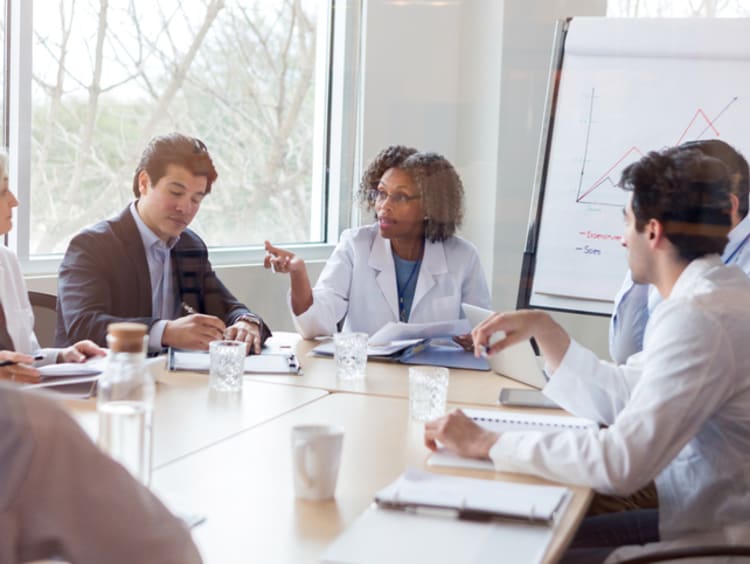 Female doctor discussing qualitative research data with her colleagues 