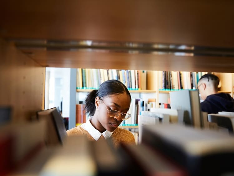 Woman standing in front of bookshelf