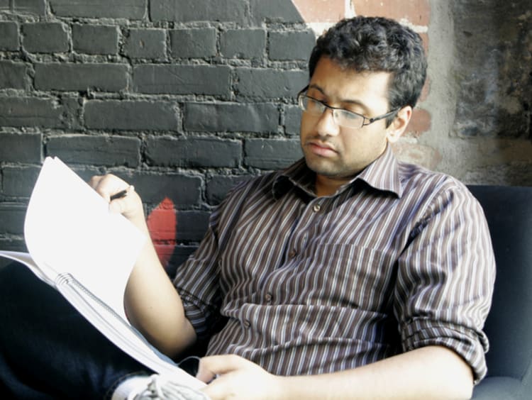 Man looking at notebook in chair